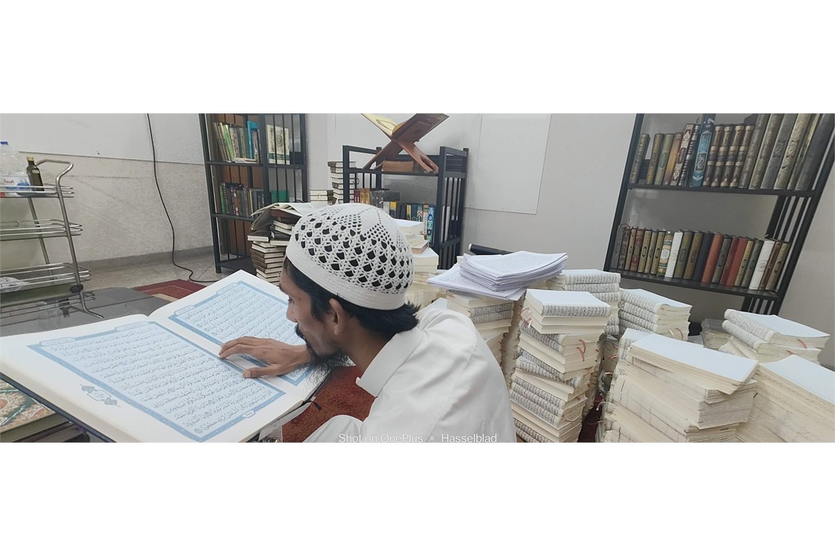 Workers applying covers to bound Mushaf copies